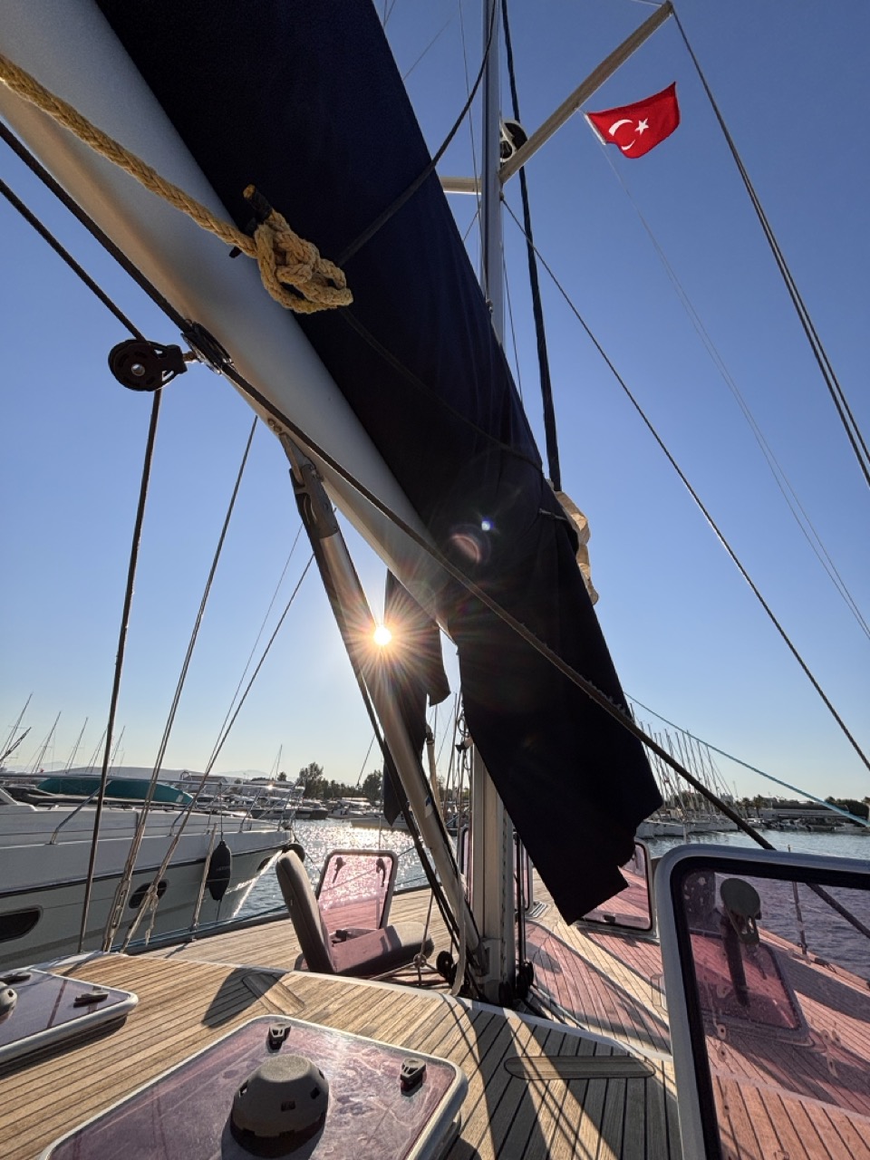 Morning sun rising through the rigging at Teos Marina, Turkish flag at the spreader